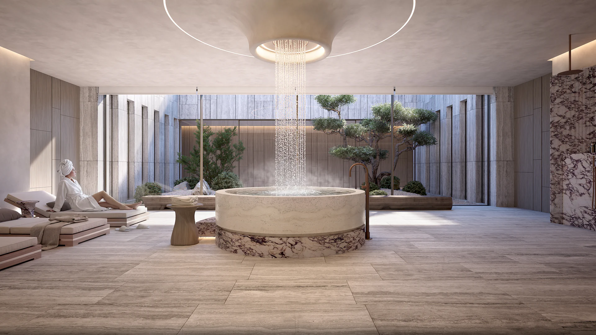 A woman reclining on a sun lounger is an interior scene from a luxury villa, featuring a fountain with water cascading from the ceiling. Project NARA by Manuel Ruiz ARK Architects